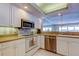 Well-lit kitchen with white cabinets, stainless steel appliances, and a view to the dining area at 895 S Gulfview Blvd # 309, Clearwater Beach, FL 33767