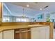 Charming kitchen view of the living area featuring a stainless steel dishwasher and breakfast bar at 895 S Gulfview Blvd # 309, Clearwater Beach, FL 33767