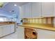 Kitchen desk area with white cabinets and a view to the dining and living areas at 895 S Gulfview Blvd # 309, Clearwater Beach, FL 33767