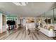 Bright living room featuring hardwood floors, mirrored walls, and comfortable couches at 895 S Gulfview Blvd # 309, Clearwater Beach, FL 33767