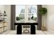 Modern home office with large windows, decorative shelving, and a black desk, creating a stylish and functional workspace at 9340 Gladsome Dr, Land O Lakes, FL 34637