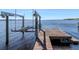 Close up of boat lift on a wooden dock and blue water under a clear sky at 1162 Tookes Rd, Tarpon Springs, FL 34689