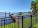 Dock with boat lift that stretches out onto the water, with a fence and grass in the foreground at 1162 Tookes Rd, Tarpon Springs, FL 34689