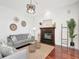 Cozy living room with a fireplace, decor, gray sofa, and wood floors at 1162 Tookes Rd, Tarpon Springs, FL 34689
