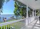 Covered porch has lake views and white railings at 1162 Tookes Rd, Tarpon Springs, FL 34689