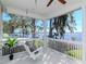 Porch view of lake with swing, railings and ceiling fan at 1162 Tookes Rd, Tarpon Springs, FL 34689