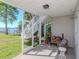 Screened porch showcasing a cozy lounge area and stairs leading to backyard and waterfront views at 1162 Tookes Rd, Tarpon Springs, FL 34689