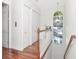 A beautifully designed staircase with wooden railing, hardwood floors, and a window providing natural light at 1162 Tookes Rd, Tarpon Springs, FL 34689