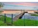 Waterfront view featuring a private dock and boat lift along the fenced backyard enhancing property access at 1162 Tookes Rd, Tarpon Springs, FL 34689