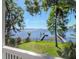 Serene waterfront view featuring a backyard, a dock, and glistening water under a clear sky at 1162 Tookes Rd, Tarpon Springs, FL 34689