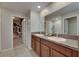 Bathroom featuring a double vanity, granite countertop, and walk-in closet at 11828 Miracle Mile Dr, Riverview, FL 33578