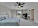Large bedroom with a window and workspace featuring carpet flooring, ceiling fan, and neutral walls at 11828 Miracle Mile Dr, Riverview, FL 33578