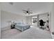 Bright bedroom with carpet flooring, a ceiling fan, a large window, and a functional workspace at 11828 Miracle Mile Dr, Riverview, FL 33578