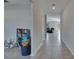 Tiled hallway view leading to a seating area, featuring a bookshelf at 11828 Miracle Mile Dr, Riverview, FL 33578
