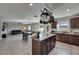 Open kitchen with island, granite countertops, dark wood cabinets, and stainless steel appliances at 11828 Miracle Mile Dr, Riverview, FL 33578
