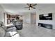 Living room with tile flooring, ceiling fan, open kitchen, and a television at 11828 Miracle Mile Dr, Riverview, FL 33578