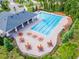 Aerial view of the community pool featuring lounge chairs, tables with umbrellas and adjacent covered area at 11828 Miracle Mile Dr, Riverview, FL 33578