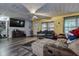Cozy living room with entertainment center, ceiling fan, and ample natural light, creating a warm atmosphere at 15204 Westminister Ave, Clearwater, FL 33760