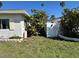 Side yard with greenery and a white privacy fence at 15507 Redington Dr, Redington Beach, FL 33708