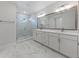 Modern bathroom featuring a marble tile floor, glass shower and double sink vanity with framed mirror at 1627 48Th N Ave, St Petersburg, FL 33714