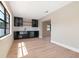Modern bar area features black cabinetry, light wood floors and a wine refrigerator at 1981 Briarwood St, Dunedin, FL 34698