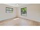 Light filled bedroom featuring two windows and light wood floors at 1981 Briarwood St, Dunedin, FL 34698