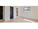 Bedroom features light hardwood floors and a view into the updated bathroom at 1981 Briarwood St, Dunedin, FL 34698