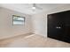 Bright bedroom boasts a ceiling fan, black closet doors and a large window at 1981 Briarwood St, Dunedin, FL 34698