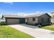 Stylish home featuring a long driveway, garage, complemented by fresh landscaping at 1981 Briarwood St, Dunedin, FL 34698
