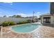 Backyard pool with brick-laid patio, plants, and white fence, perfect for outdoor relaxation at 1981 Briarwood St, Dunedin, FL 34698