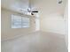 Bright and airy living room with neutral walls, ceiling fan, and large window at 2122 Holiday Dr, Holiday, FL 34691