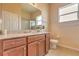 Well-lit bathroom with wood cabinets, granite countertop, and a window providing natural light at 2218 132Nd E Pl, Parrish, FL 34219