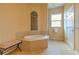 Bathroom featuring a soaking tub with tiled surround, large window, and tiled floors at 2218 132Nd E Pl, Parrish, FL 34219