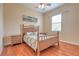 Bright bedroom with hardwood floors, ceiling fan, and a picturesque tropical print at 2218 132Nd E Pl, Parrish, FL 34219