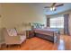 Comfortable bedroom with a large bed, accent chair, wooden floors, and natural light from the window at 2218 132Nd E Pl, Parrish, FL 34219