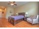 Bedroom with a wooden bed, hardwood floors, a ceiling fan, side tables with lamps, and an arched doorway at 2218 132Nd E Pl, Parrish, FL 34219