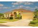 Stunning yellow home with a manicured lawn, beautiful landscaping, and a two-car garage at 2218 132Nd E Pl, Parrish, FL 34219
