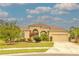 Charming single Gathering home showcasing its manicured lawn, mature landscaping, and an attached two car garage at 2218 132Nd E Pl, Parrish, FL 34219