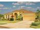 Charming single Gathering home showcasing its manicured lawn, mature landscaping, and an attached two car garage at 2218 132Nd E Pl, Parrish, FL 34219
