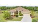 Inviting front exterior featuring a well-manicured lawn, mature landscaping, and a charming entryway at 2218 132Nd E Pl, Parrish, FL 34219