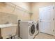 Practical laundry room complete with washer, dryer, sink, and ample storage at 2218 132Nd E Pl, Parrish, FL 34219
