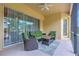 Covered patio with outdoor furniture, ceiling fan, and views of the backyard, with sliding glass doors for indoor/outdoor living at 2218 132Nd E Pl, Parrish, FL 34219