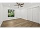 Bright bedroom with laminate flooring, a ceiling fan, a large window, and a closet with sliding doors at 2328 Dartmouth N Ave, St Petersburg, FL 33713