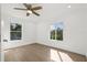 Well-lit bedroom with laminate flooring, neutral walls, two windows, and a ceiling fan at 2328 Dartmouth N Ave, St Petersburg, FL 33713