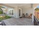 Cozy covered front porch with tile flooring, seating, and a welcoming entrance door at 2328 Dartmouth N Ave, St Petersburg, FL 33713