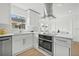 A brightly lit modern kitchen features stainless steel appliances, white cabinets, a large island, and updated flooring at 2328 Dartmouth N Ave, St Petersburg, FL 33713
