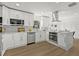 A bright and modern kitchen features stainless steel appliances, white cabinets, a large island, and updated flooring at 2328 Dartmouth N Ave, St Petersburg, FL 33713