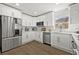 A modern kitchen featuring stainless steel appliances, white cabinetry, and updated flooring with plenty of natural light at 2328 Dartmouth N Ave, St Petersburg, FL 33713