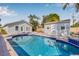 Lush backyard showcasing a refreshing swimming pool, outdoor seating area, pool house, and meticulous landscaping at 2328 Dartmouth N Ave, St Petersburg, FL 33713
