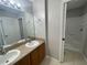 Well-lit bathroom featuring a double sink vanity and a shower with a tub at 2520 Edgewater Falls Dr, Brandon, FL 33511